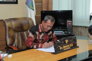 The MAyor signing the handover document
